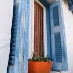 Most of the houses in the neighborhood are whitewashed with blue shuttered windows.